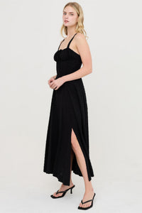 Robe noire à bretelles, décolleté carré, jupe fendue sur le côté