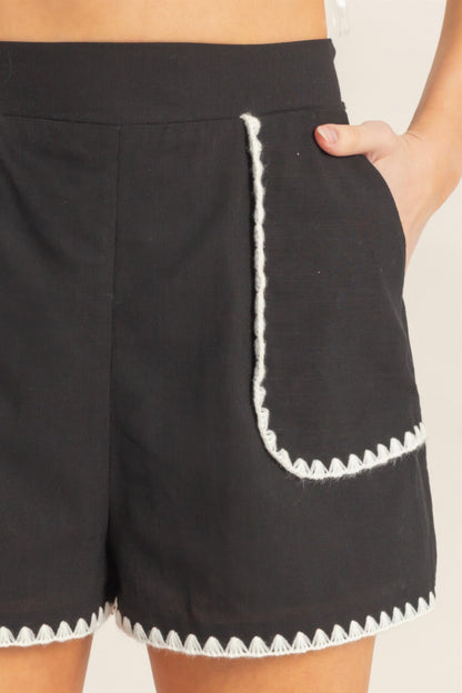 Shorts taille haute noir détail poche à bordure festonnée blanche
