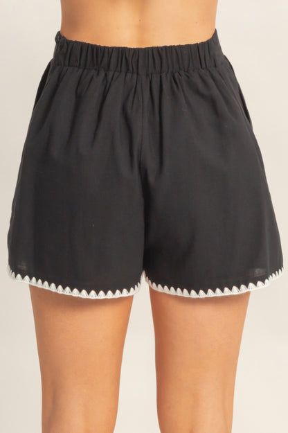 Shorts taille haute noirs avec bord festonné et ourlet à pointes contrastées