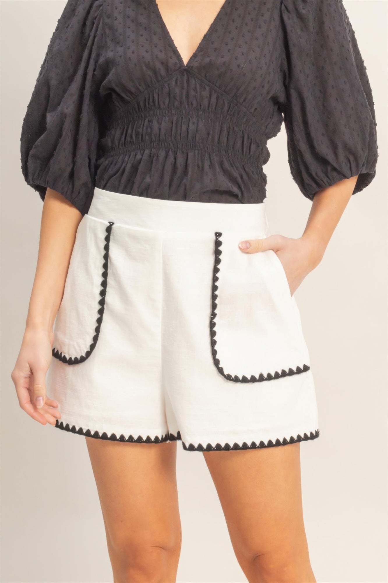 Shorts taille haute blancs avec bord festonné noir et poche en appliqué