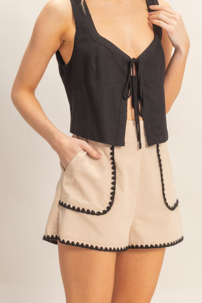 Shorts taille haute beige à bordure festonnée noire, poches arrondies
