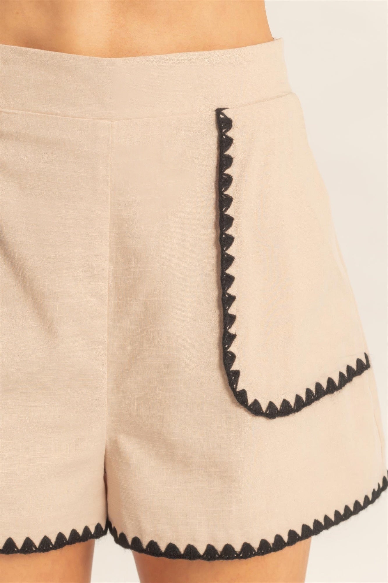 Shorts taille haute beige détail bordure festonnée noire sur poche
