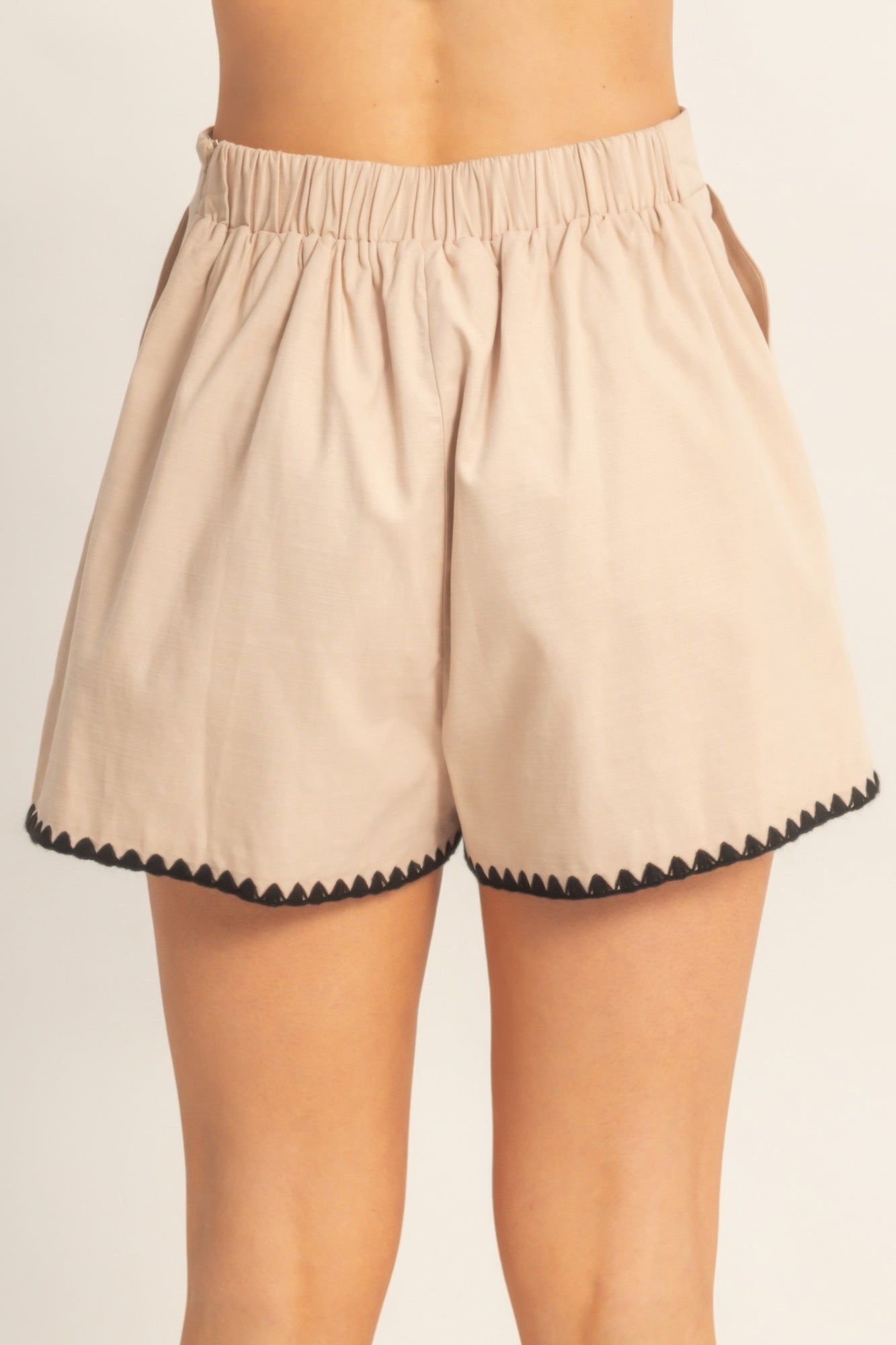 Shorts taille haute beige à taille élastique et bordure festonnée noire