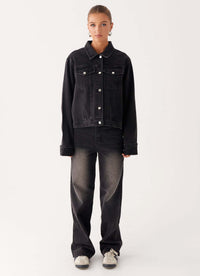 Veste en jean noire pour femme, boutonnage central, poches avant et col chemise.