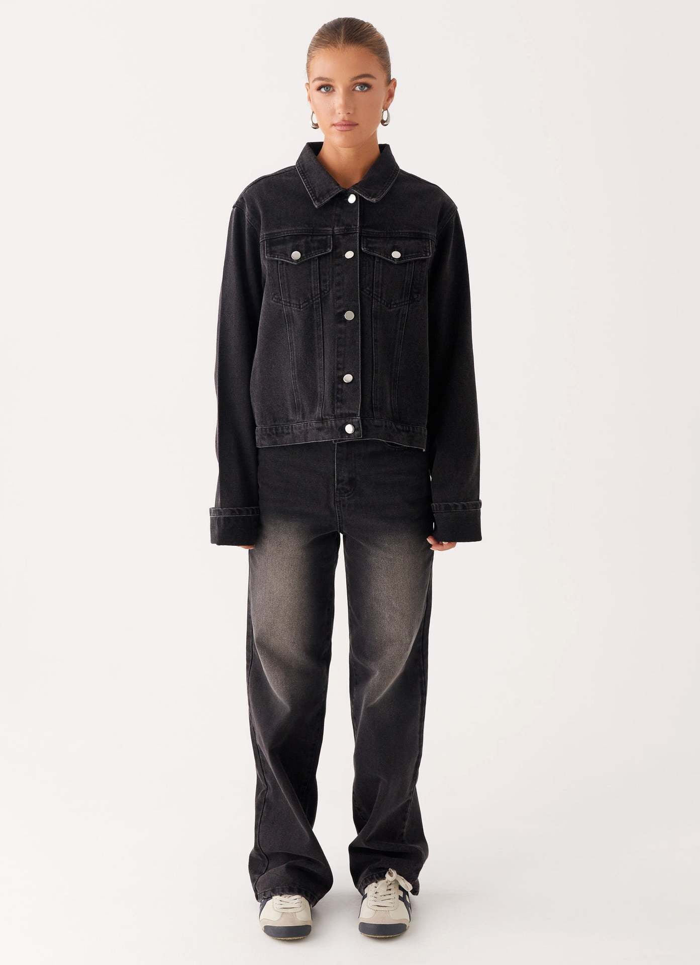 Veste en jean noire pour femme, boutonnage central, poches avant et col chemise.