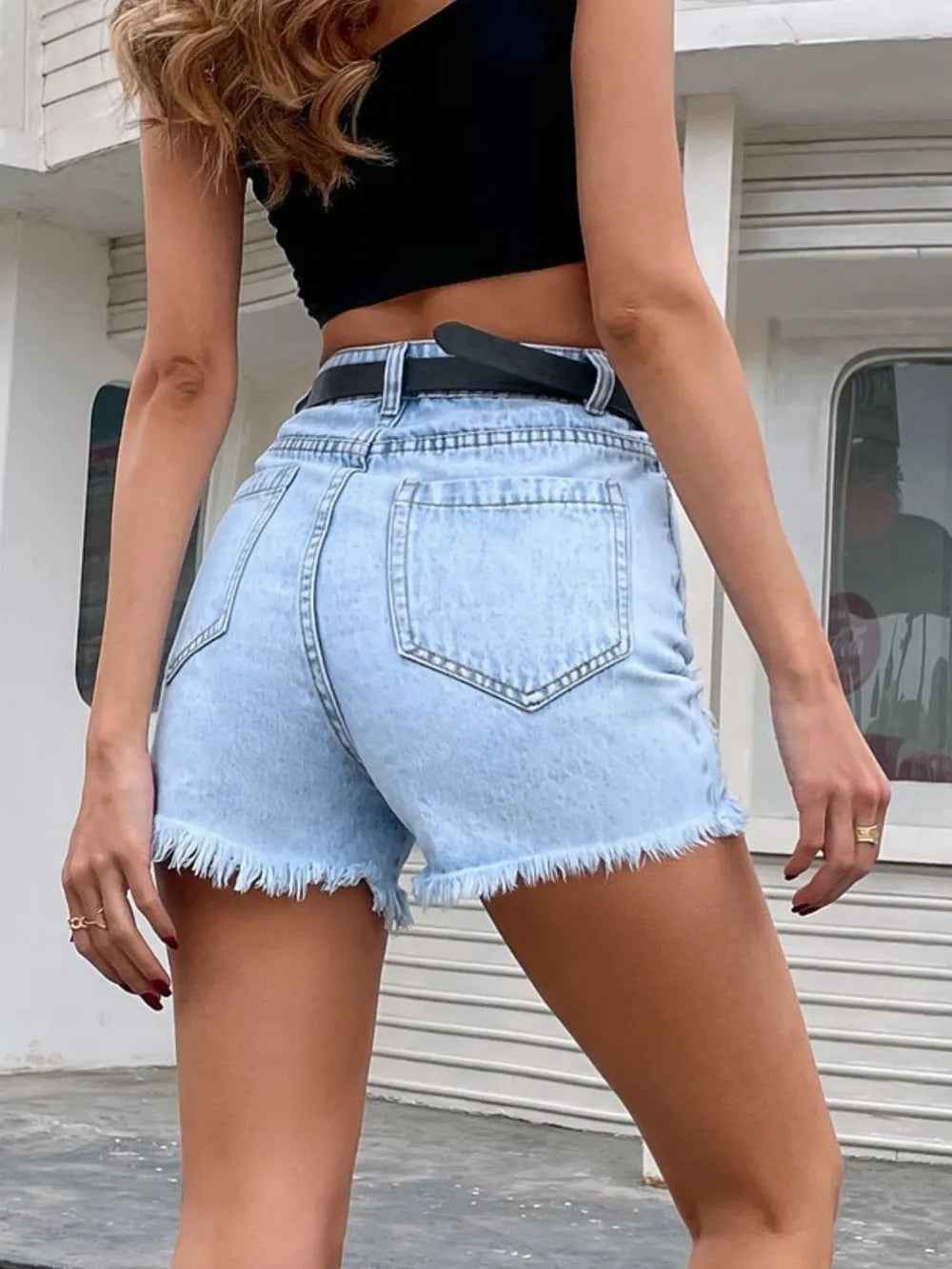 Short en jean bleu clair taille ceinturée avec poches arrière, déchirures latérales et ourlet