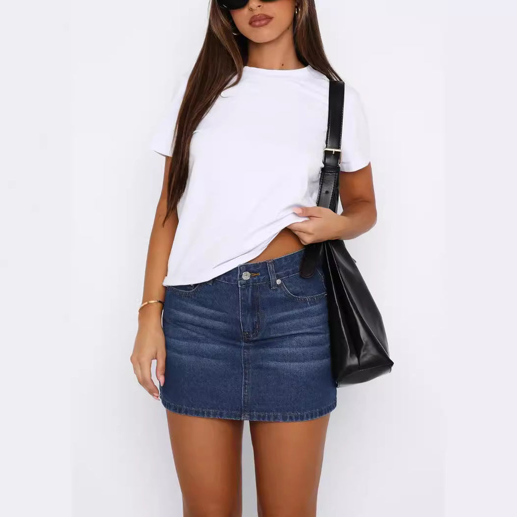 Mini jupe en jean bleu foncé, boutonnée, poches devant, longueur au-dessus du genou.