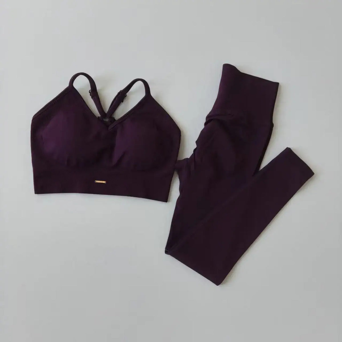 Ensemble sport femme violet foncé : brassière et leggings taille haute assortis.