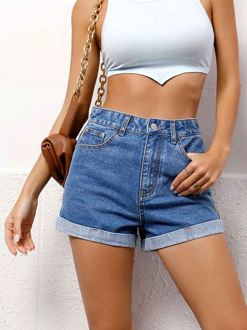 Short en jean taille haute bleu avec poches et fermeture boutonnée.