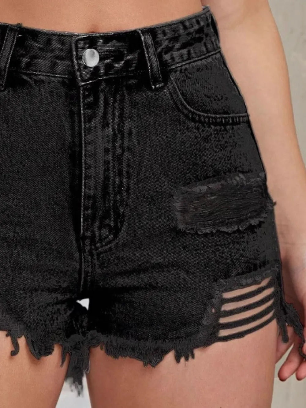 Short taille haute en jean noir usé, détails des poches et ourlet frangé