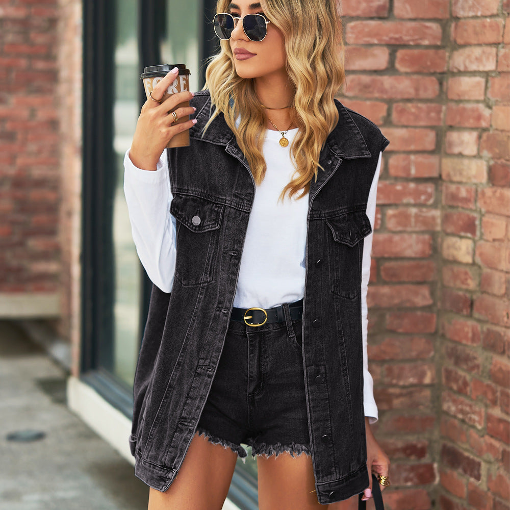 Veste en jean mi-longue noire sans manches, poches poitrine, fermeture à boutons.