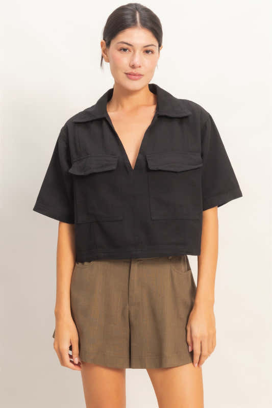 Haut femme en coton noir, col V, manches courtes, poches plaquées devant.