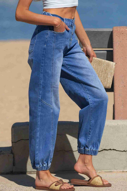 Jean bleu taille haute fuselé, poches et coutures latérales, bas resserré.
