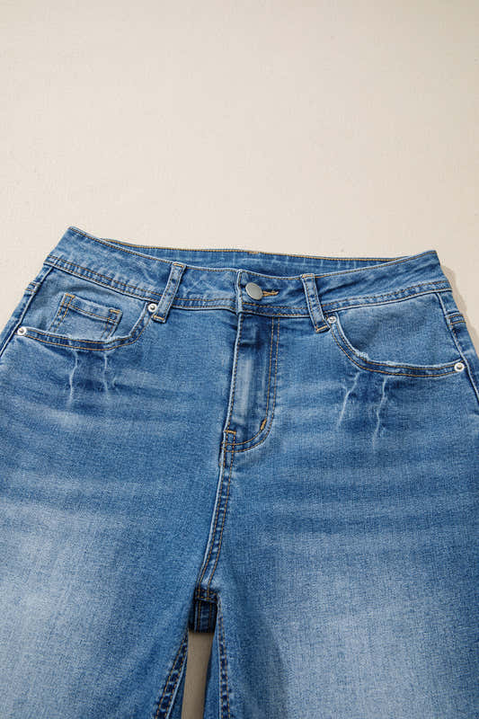 Jean taille haute bleu myosotis, ceinture avec passants et boutons à rivets.