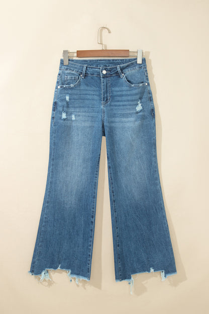 Jean flare taille haute bleu moyen, poches devant, ourlet effiloché et déchirures.