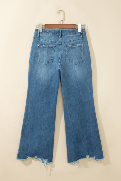 Jean flare taille haute bleu moyen, poches dos, ourlet effiloché avec bords usés.