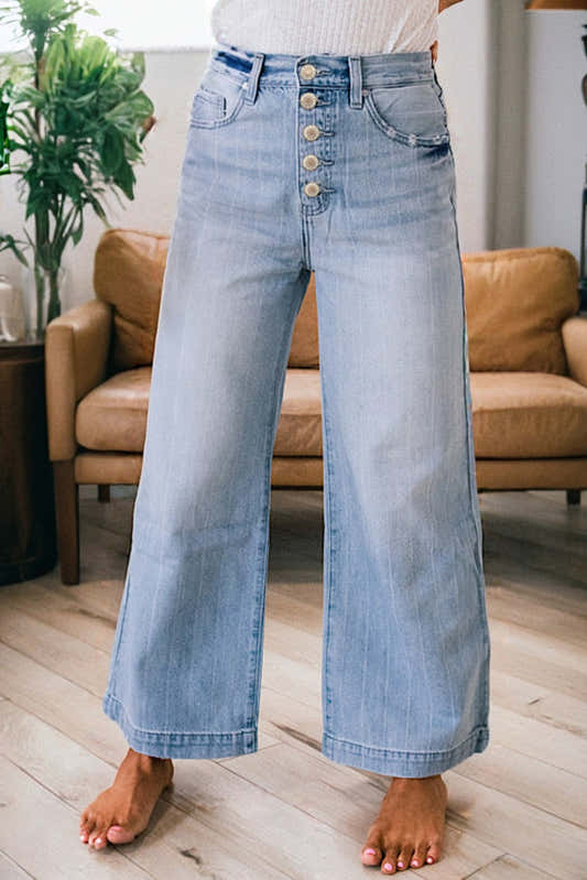 Jean bleu clair à jambes larges, boutonnage multiple devant, poches dos