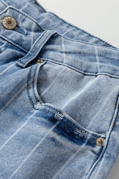 Détail jean bleu clair : ceinture boutonnée, coutures et poche latérale