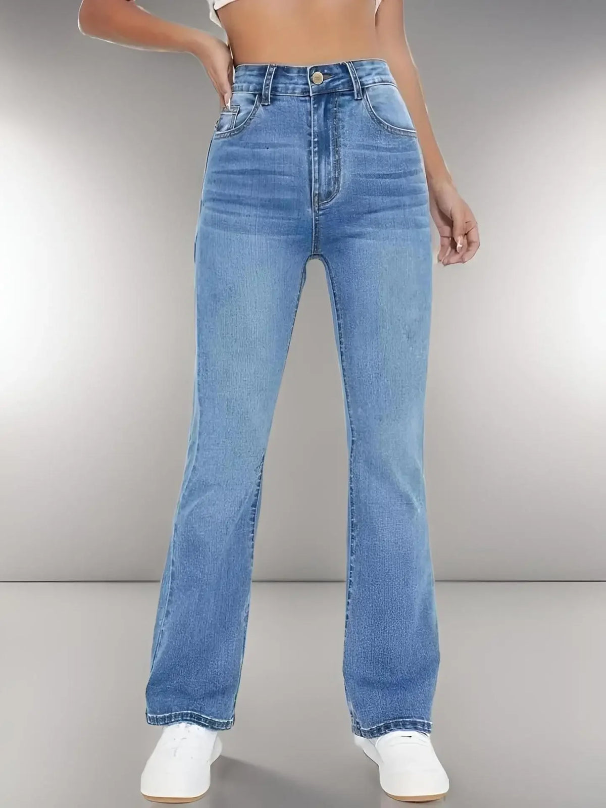 Jean taille haute en denim bleu lavé, coupe évasée, bouton métal et braguette