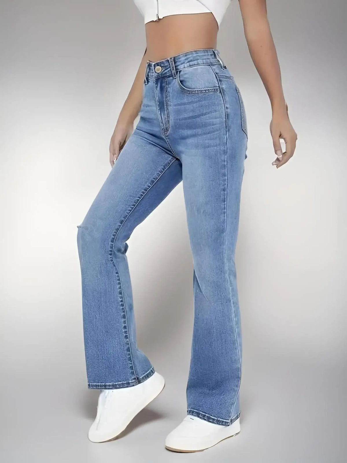 Jean taille haute en denim bleu lavé, jambes évasées, poches avant et surpiqûres