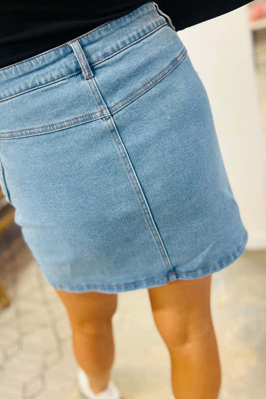 Jupe en jean bleu clair taille haute, vue de côté, poches et coutures visibles