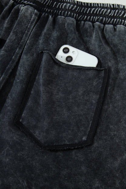 Détail pantalon noir délavé minéral : poche plaquée, taille élastique, cordon de serrage