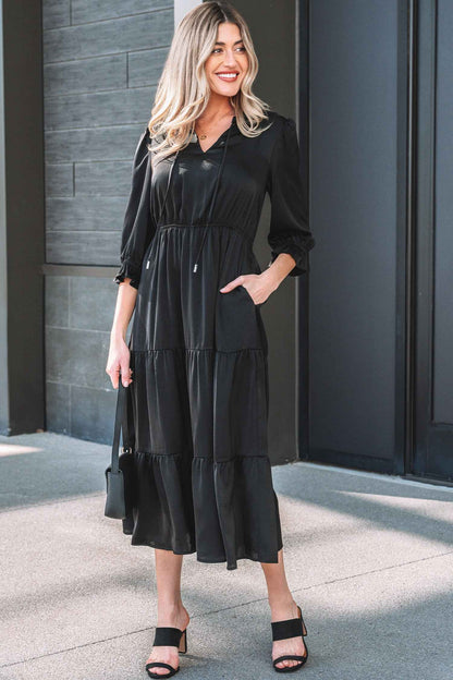 Robe maxi noire à volants étagés, encolure V, manches 3/4 bouffantes.