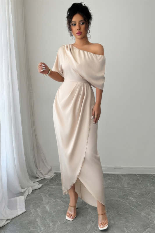 Robe asymétrique une épaule beige, manches courtes, drapé croisé et fente avant.