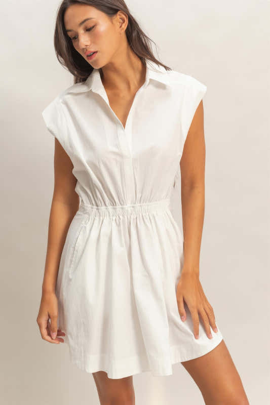 Robe mini sans manches blanc cassé, col chemise, patte boutonnée, taille froncée