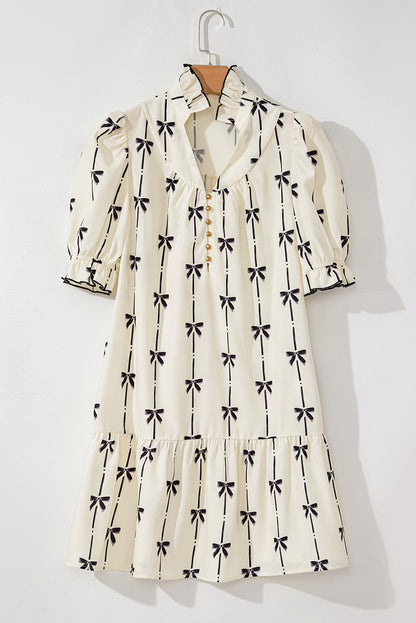 Robe courte sur cintre, crème à motifs nœuds papillon, manches bouffantes.