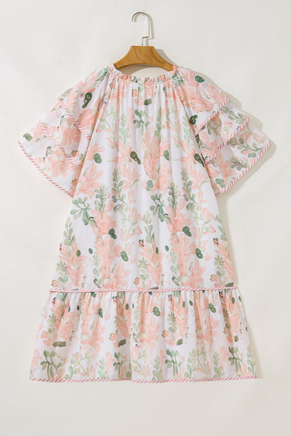 Robe courte rose à fleurs, encolure froncée, jupe à volants superposés.