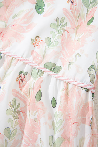 Robe courte rose à fleurs, motif feuillages vert et ruban à rayures sur l’encolure.