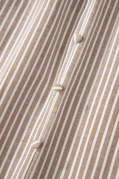 Détail de robe rayée : tissu texturé et boutons alignés au centre.