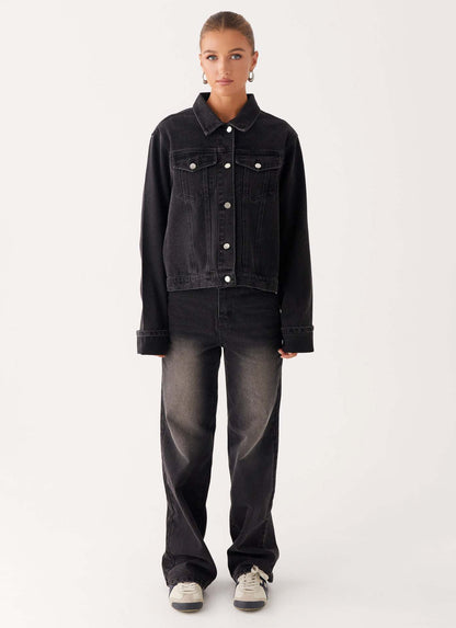 Veste en jean noire pour femme, boutonnage central, poches avant et col chemise.