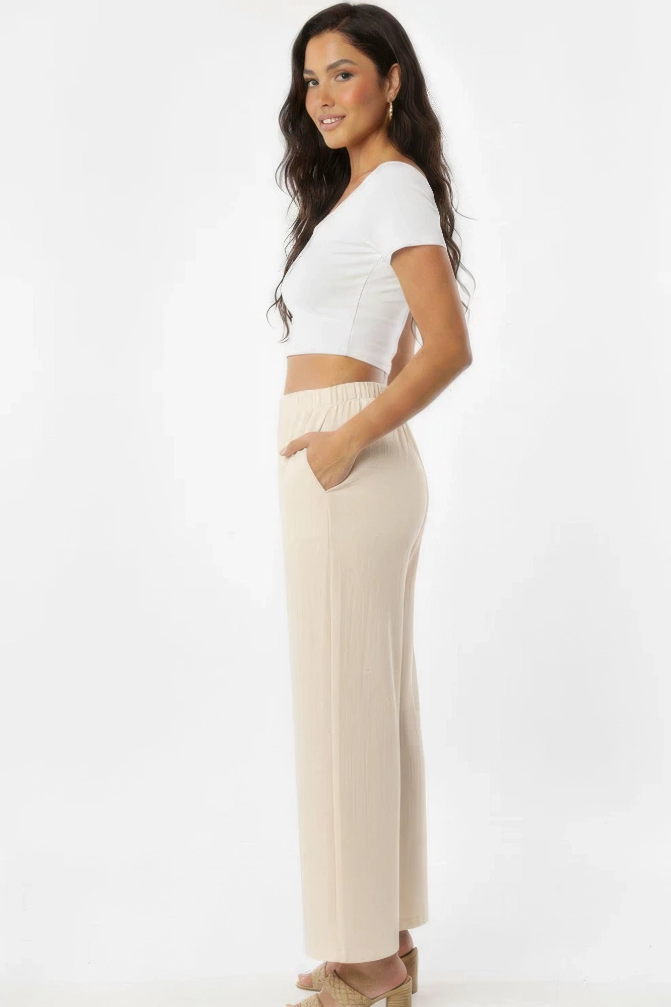 Pantalon large blanc cassé en coton, taille élastique et poches latérales.