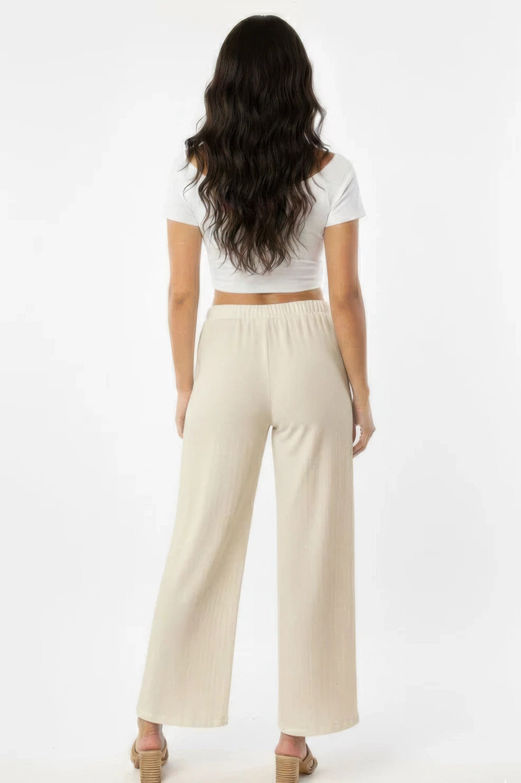 Pantalon large blanc cassé en coton, dos, taille élastique et jambe ample.