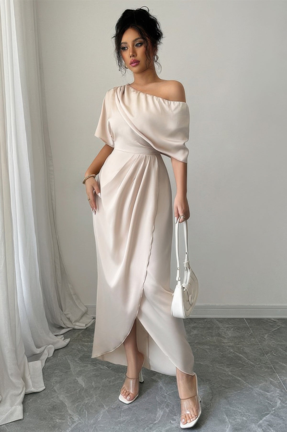 Robe midi beige une épaule, drapé croisé et fronces, jupe fendue sur le côté.