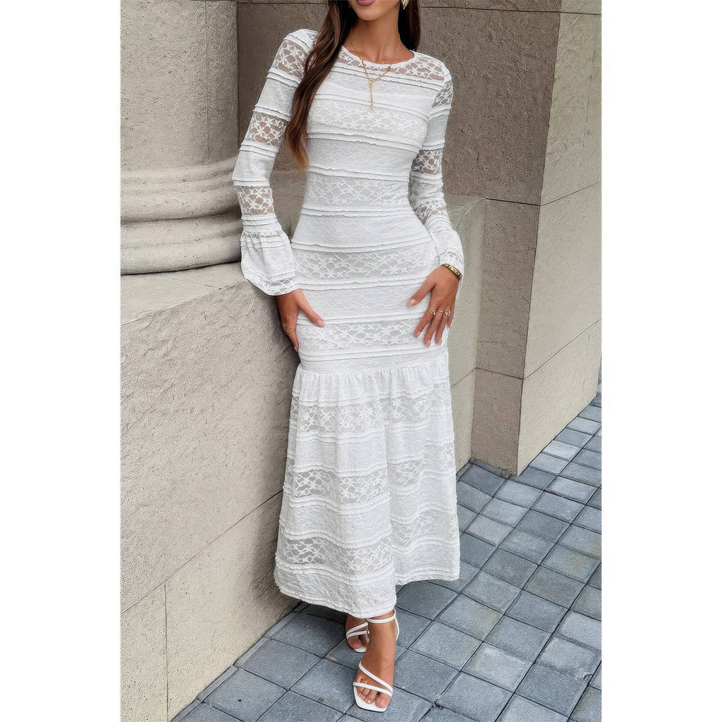 Robe longue en dentelle blanche à encolure ronde, manches longues et ourlet volanté.