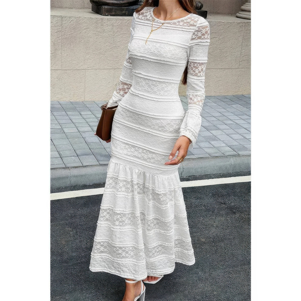Robe maxi en dentelle blanche ajustée, encolure ronde, manches longues, bas évasé à volants.
