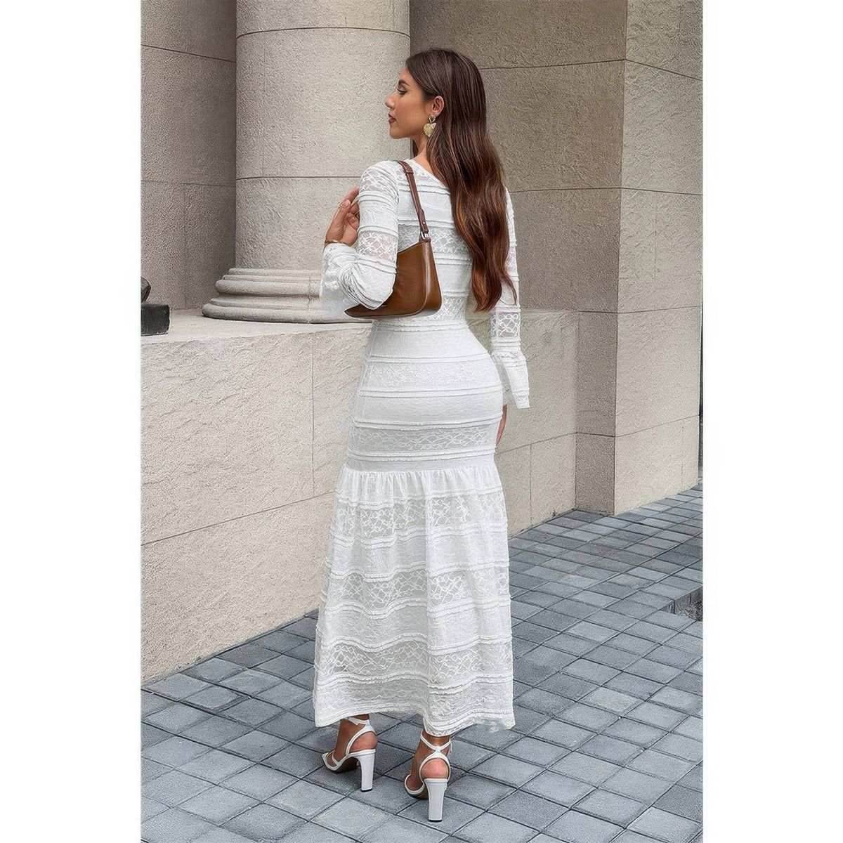 Robe maxi blanche en dentelle, dos droit, manches longues, volants superposés en bas.