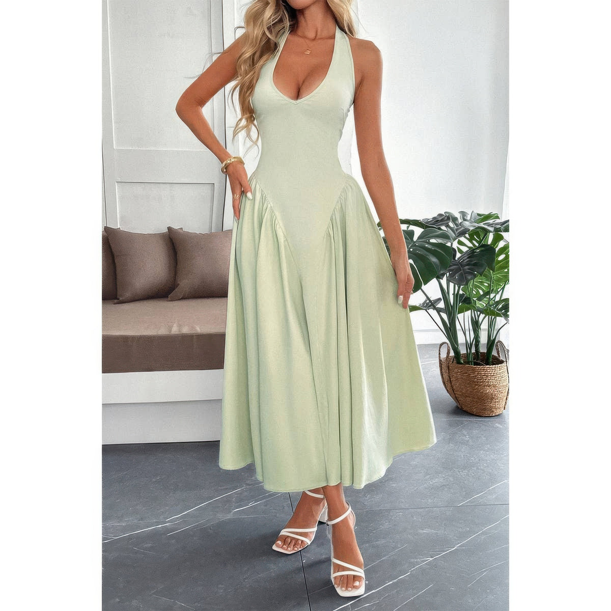 Robe midi sans manches vert clair à encolure licou, jupe évasée et zip au dos.