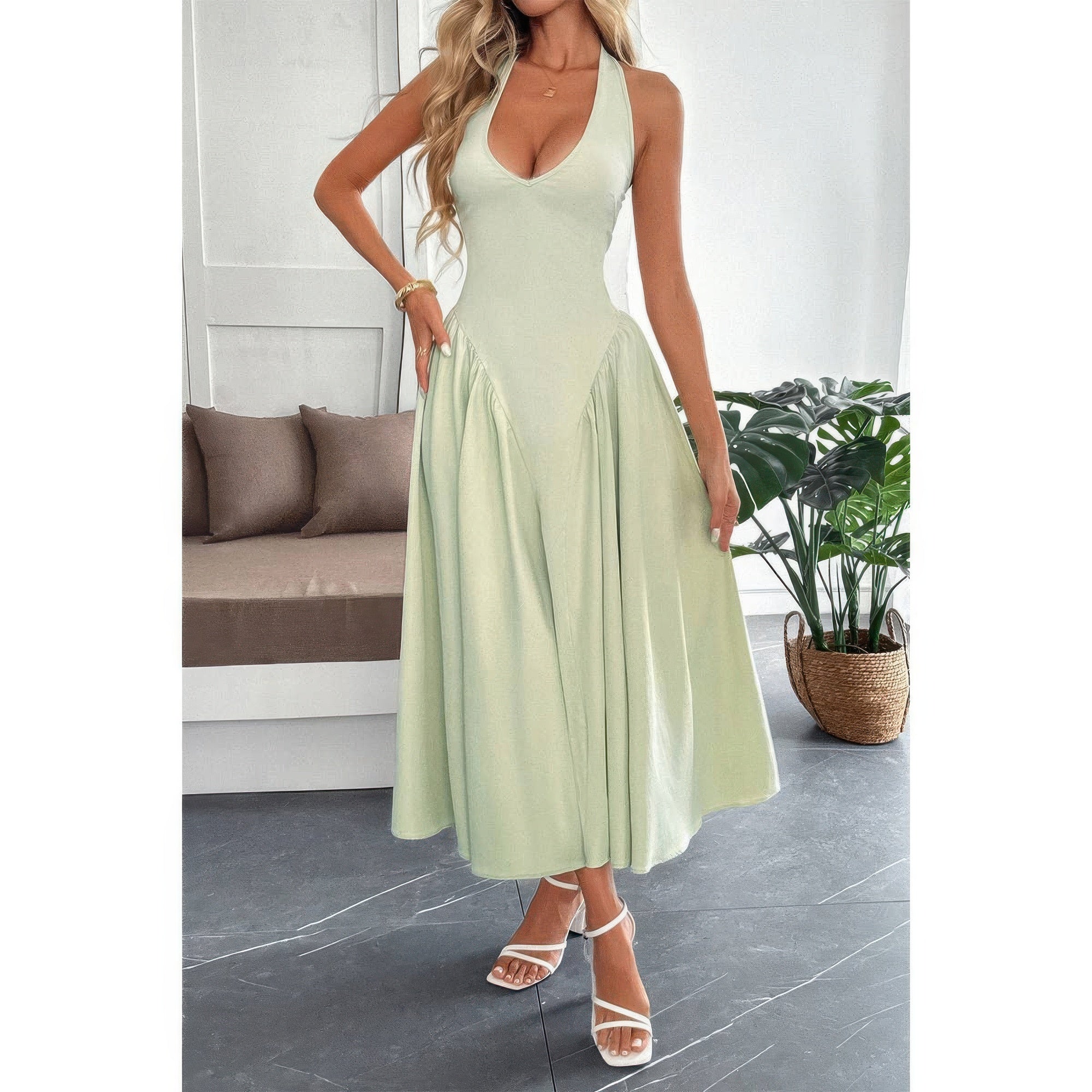 Robe midi sans manches vert clair à encolure licou, jupe évasée et zip au dos.