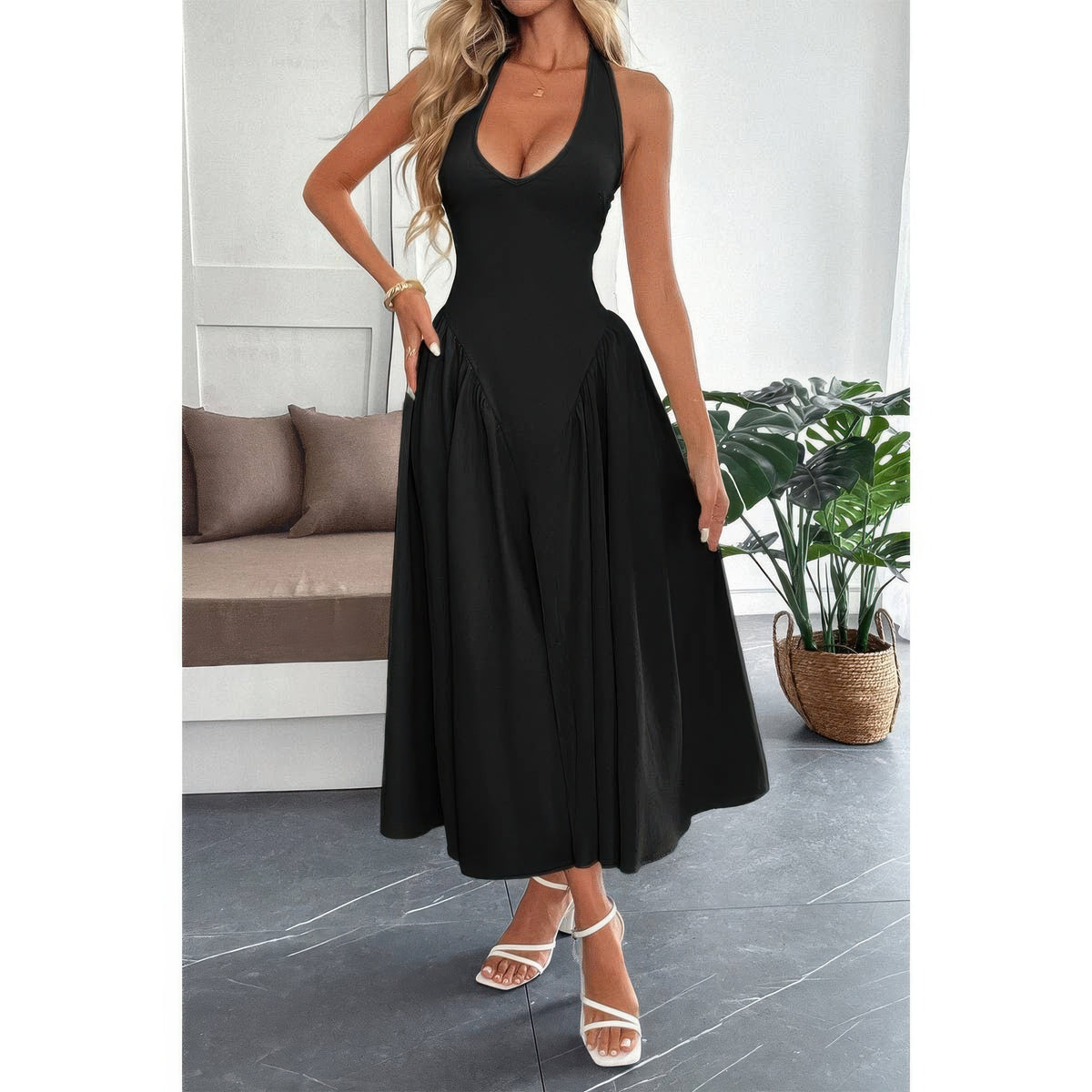 Robe midi noire sans manches col licou, jupe évasée et zip dos.