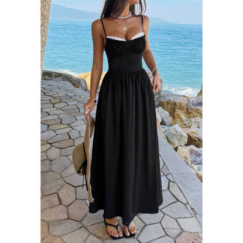 Robe longue noire à bretelles spaghetti, jupe ample froncée, bord dentelle blanche.
