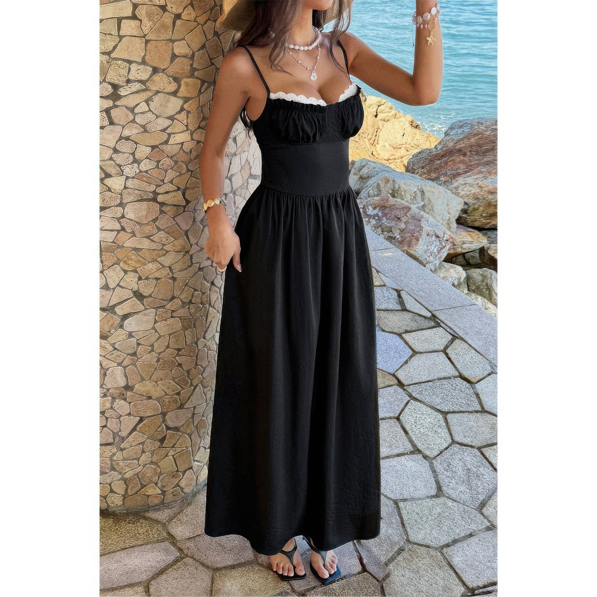 Robe longue noire, buste froncé avec bord dentelle blanche, bretelles spaghetti ajustables.
