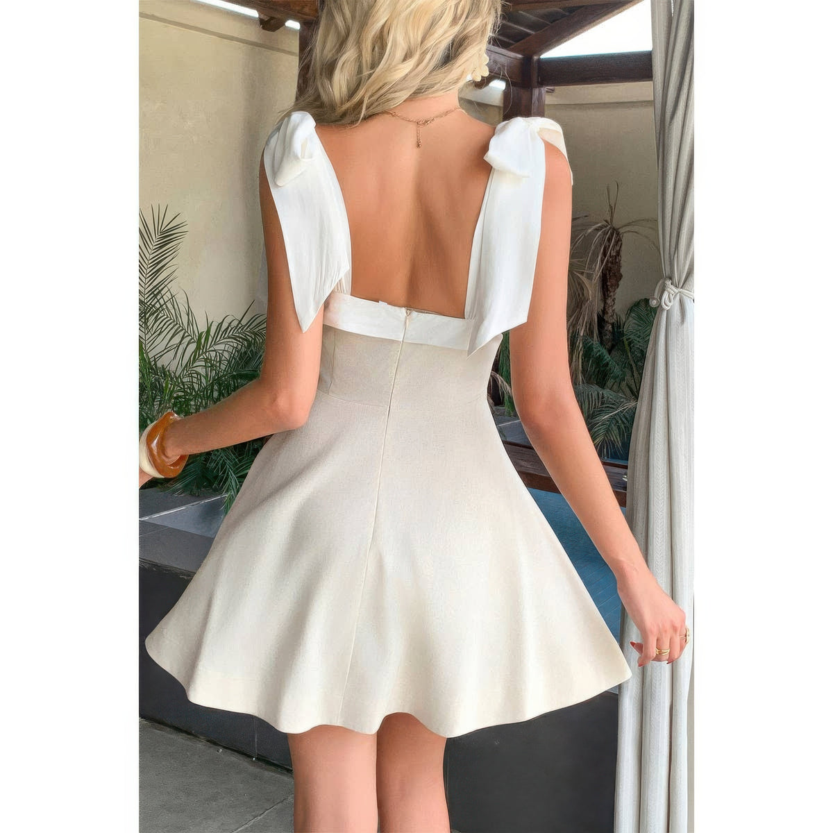 Dos de robe beige encolure carrée, liens d’épaules noués et jupe patineuse