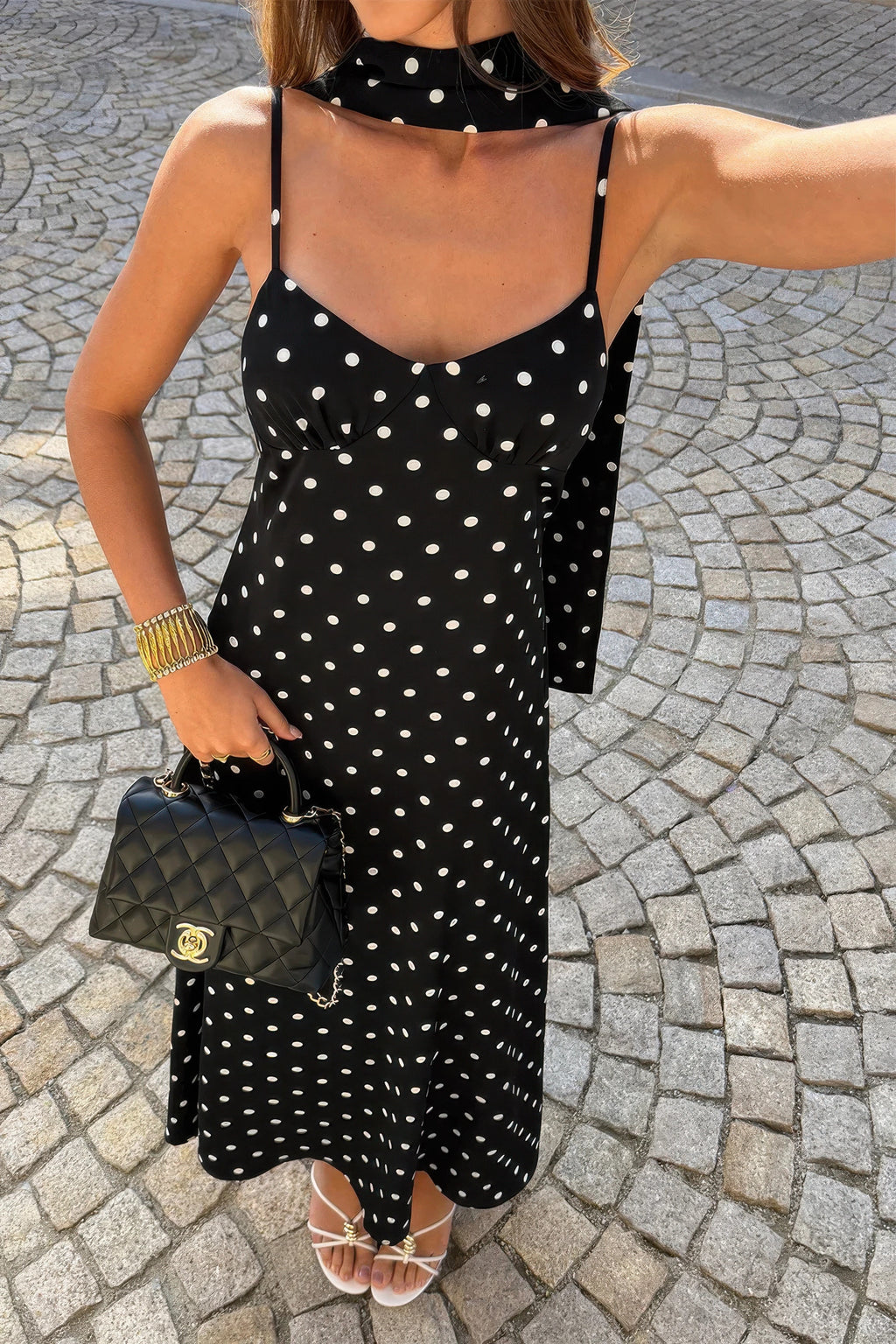 Robe nuisette noire à pois blancs, bretelles fines, encolure plongeante, longue