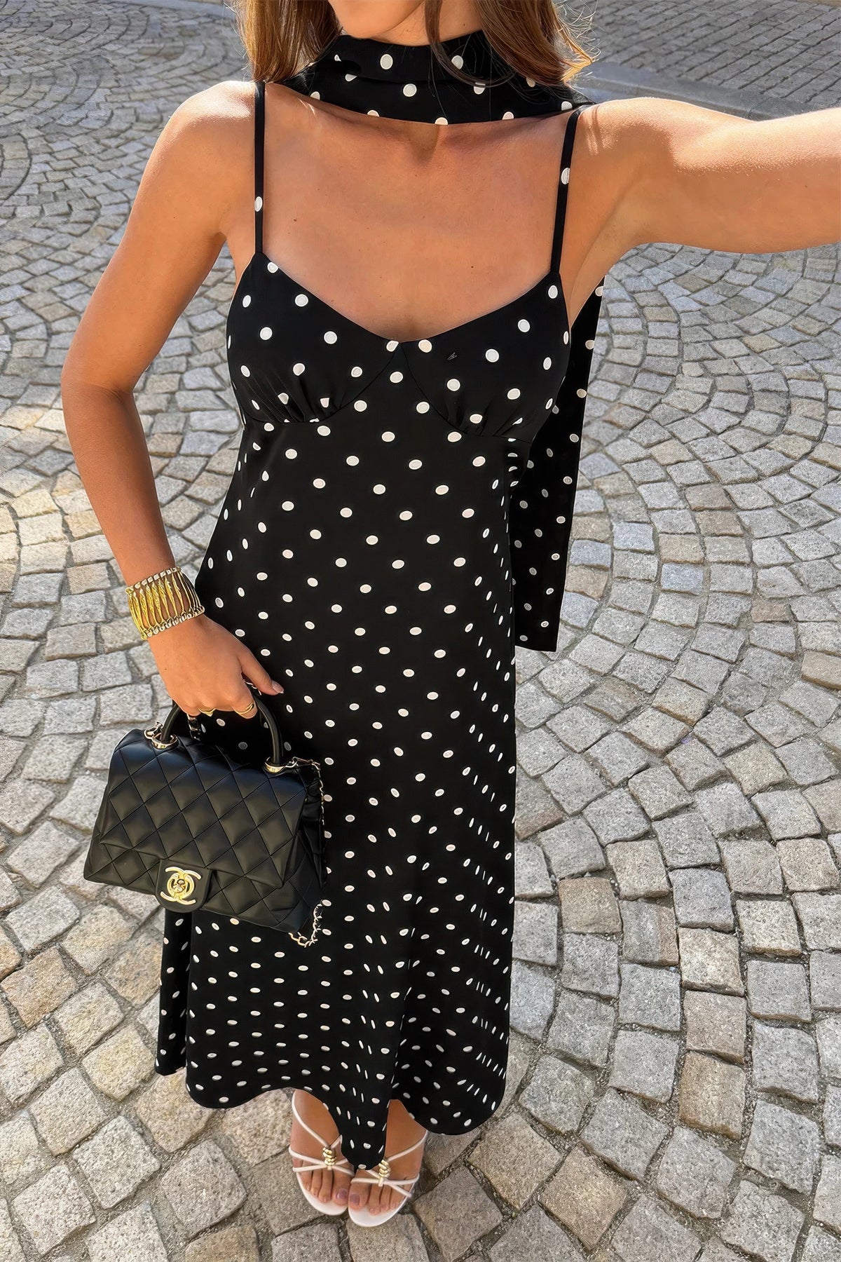 Robe nuisette noire à pois blancs, bretelles fines, encolure plongeante, longue