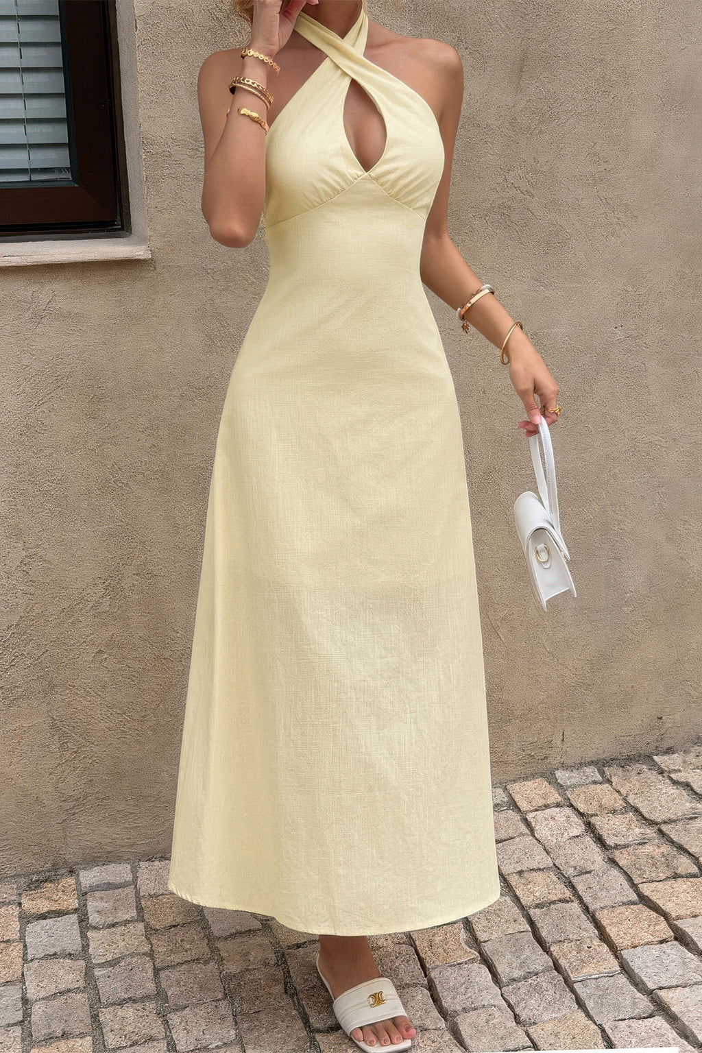 Robe longue jaune dos nu à col halter en trou-de-serrure, taille cintrée.