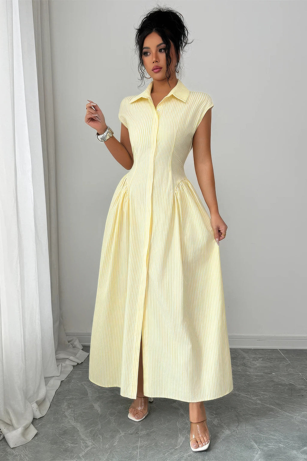 Robe longue jaune à encolure chemise, manches courtes, taille froncée, jupe évasée.